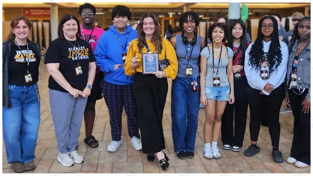 Vaughn with award, flanked by students