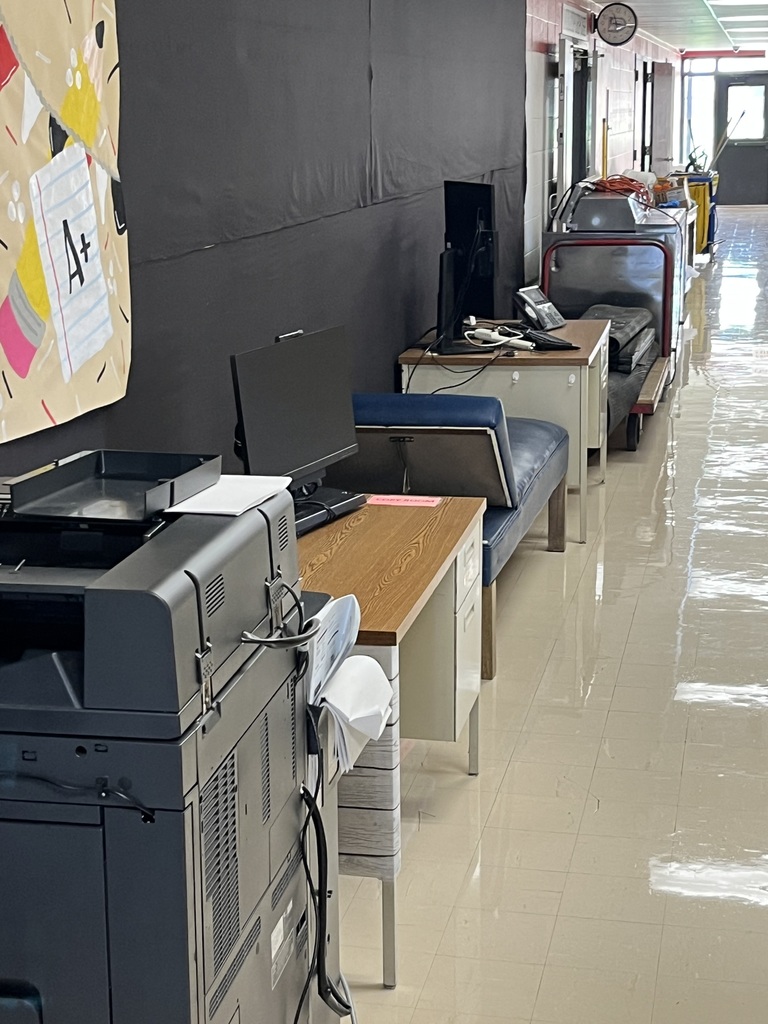 Various clinic furniture in the hallway of a school - copier, desks, etc.