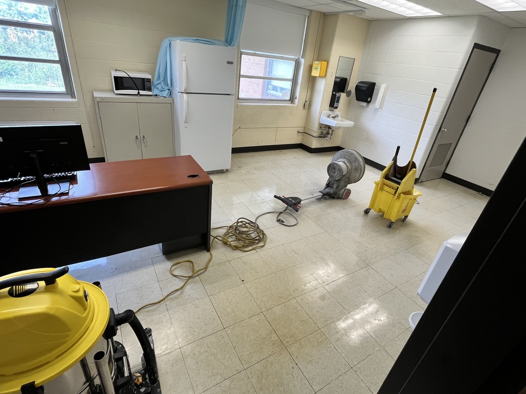 Mop, scrubber, etc. on the floor in an empty school clinic.