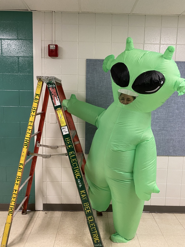Green alien climbing a ladder