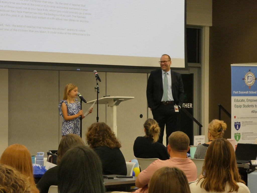 Superintendent looks on as student speaker introduces Educator of the Year