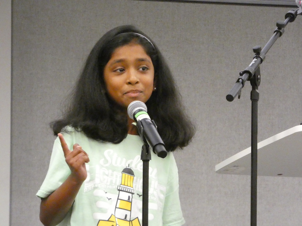 Student speaker emphasizes a point with her hand as she introduces superintendent