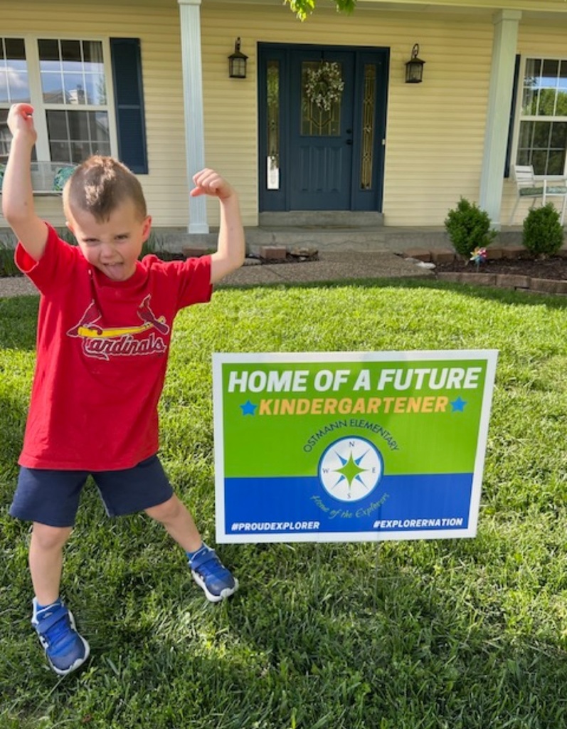 New Kindergartener, Eli poses with his hard sign