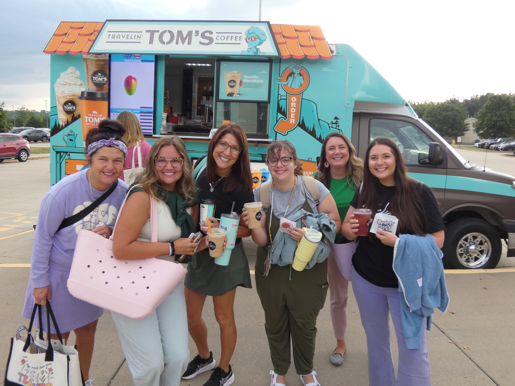 Happy teachers pose with their fresh coffee and drinks