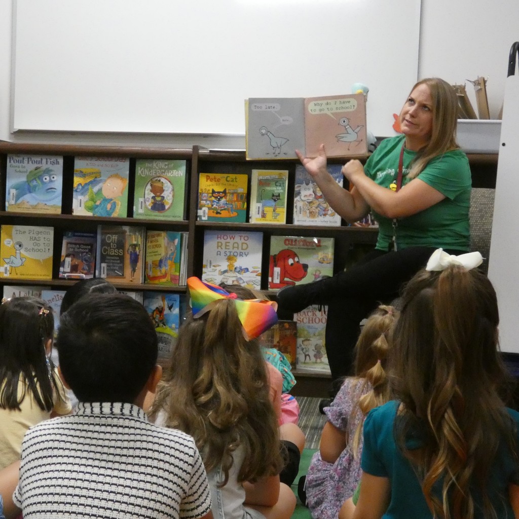 Librarian looks off with a question on her face as she shares the story of pidgeon's first day of school with kindergarners