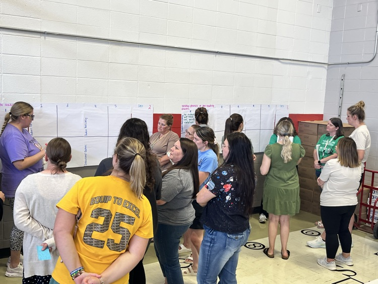 teachers in various garb working on chart paper, talking about phonics standards