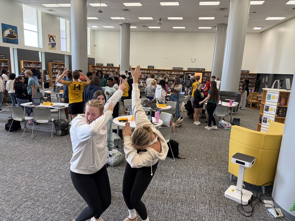 Two PPI mentors participating in an icebreaker activity during a PPI workshop in the library.
