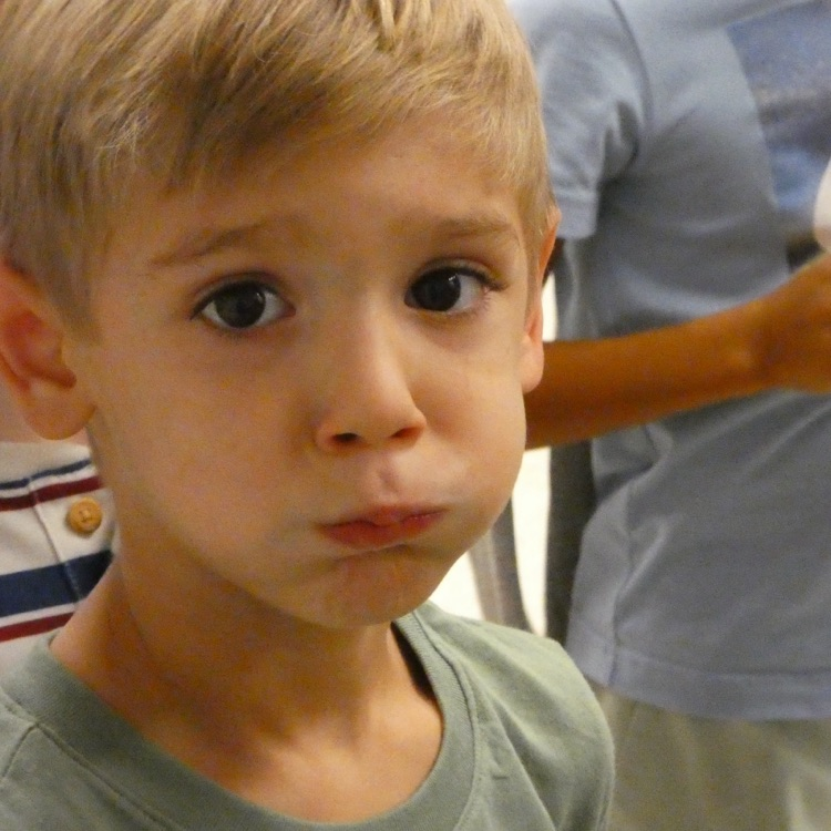 A brown-eyed student "holds a bubble" to help stay quiet in the hall. Students keep their lips closed tight and puff their cheeks to "hold the bubble"