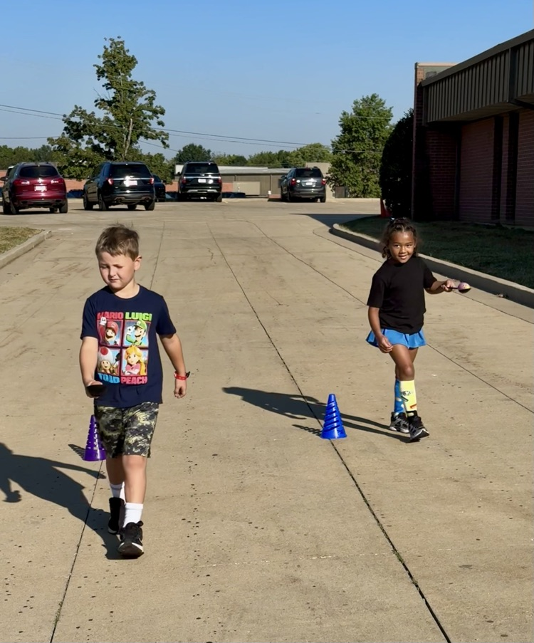 Two kids racing back holding an egg on a spoon for “Humpty Dumpty."