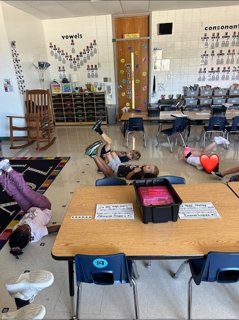 Students practicing a "dead bug" pose