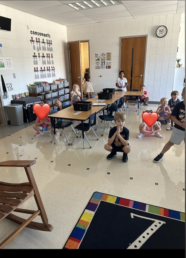 Students practicing a squatting yoga pose