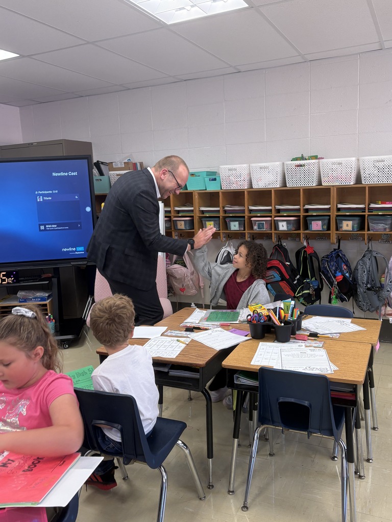 Dr. St. Pierre giving out high fives to students in Mrs. Stephen's class