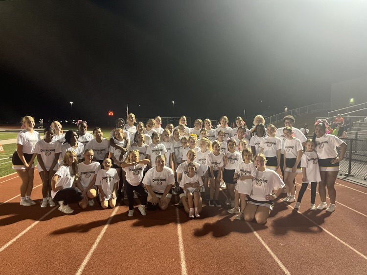 Junior cheer posing with our varsity team