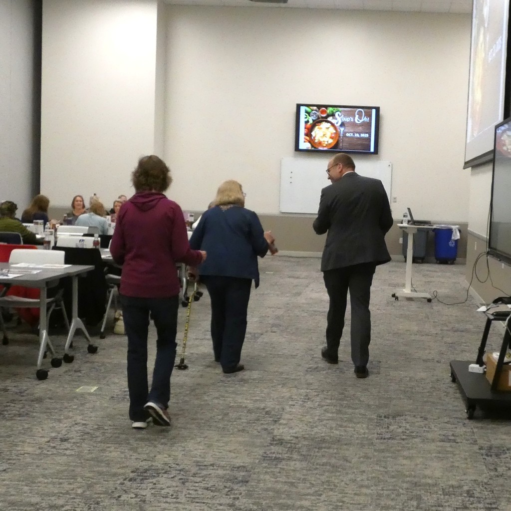 Superintendent visits with a guest as he helps carry lunch to her table