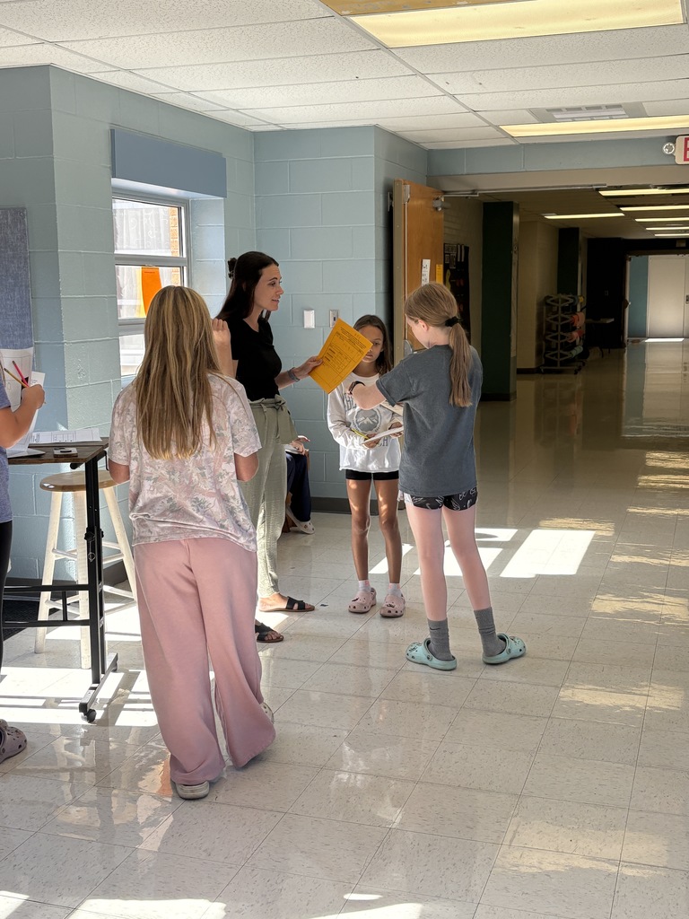 3 5th-grade students discussing with Ms. Hulett how to solve a certain math problem