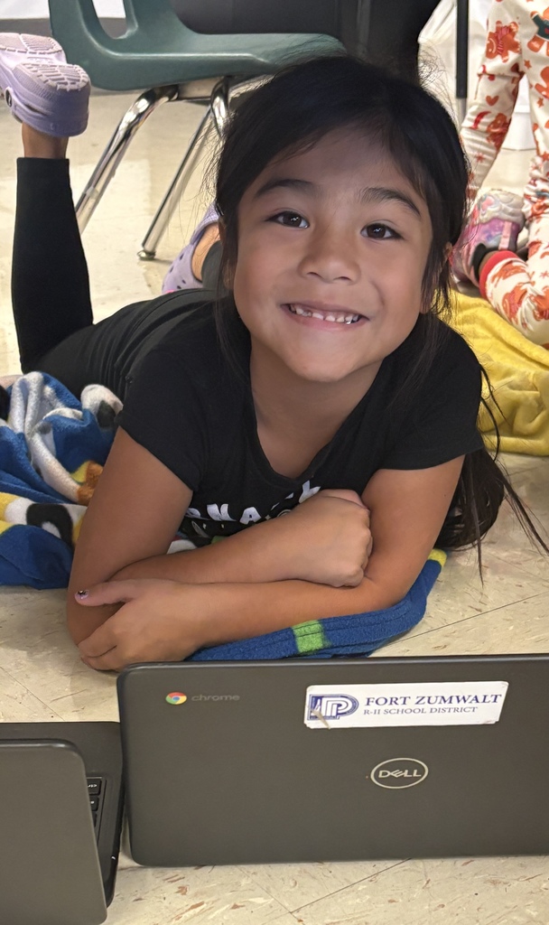 One first-grade student working on her Chromebook under her desk fort
