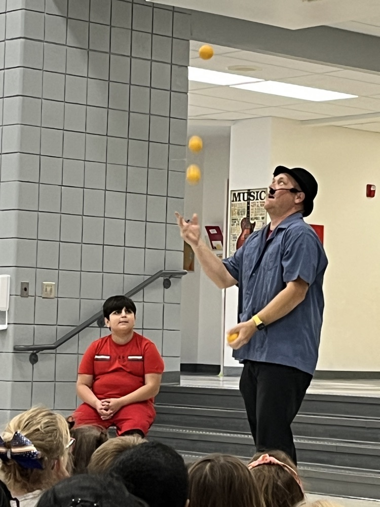 magician juggling with student volunteer