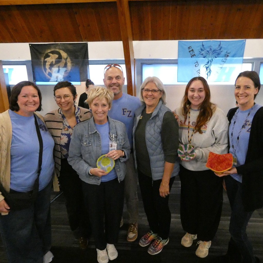 Staff from across the district pose with their ceramic bowls and bowl cozies