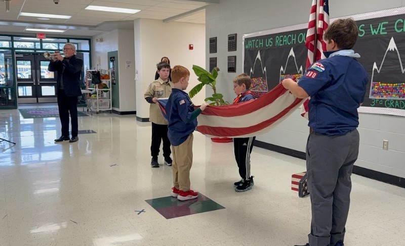 Guest musician Doug Gavin playing Taps on his trumpet and some of our boy scouts folding our flag.