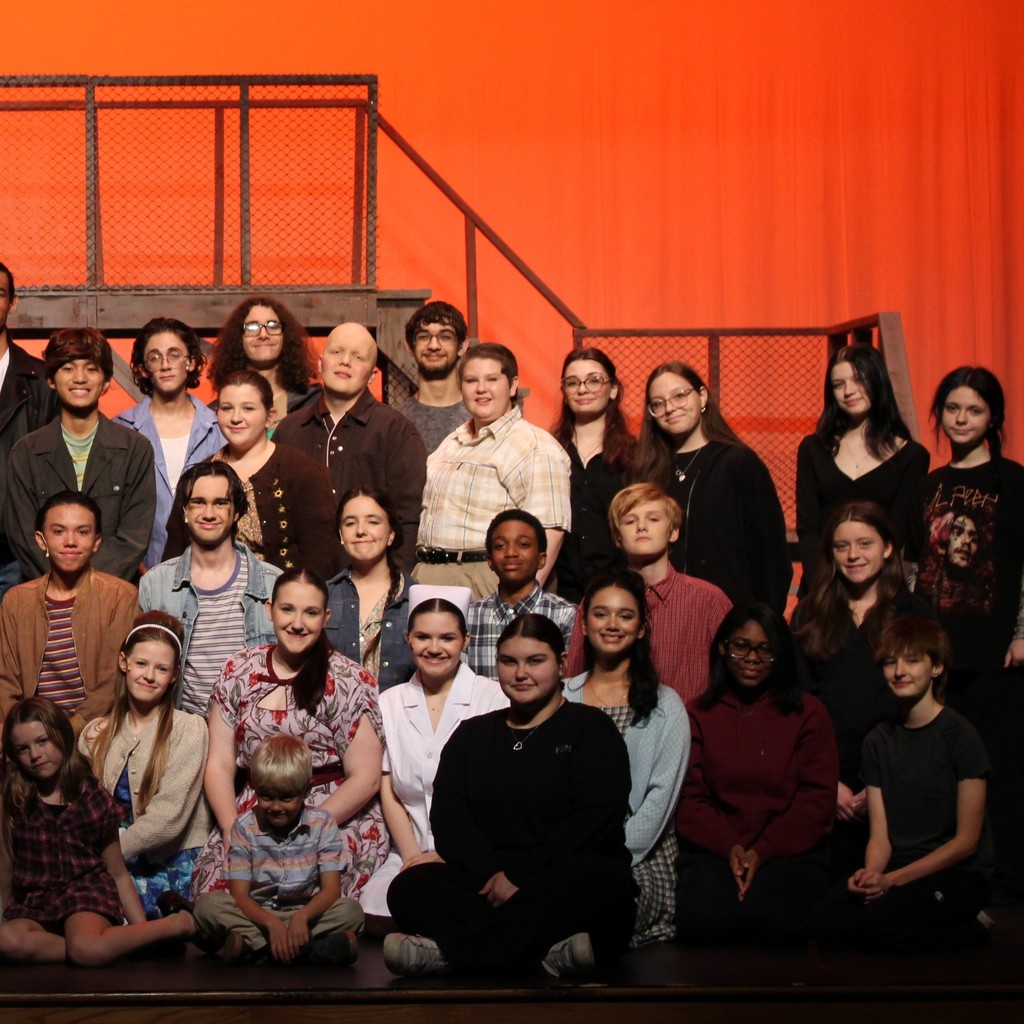 Cast and crew pose as a group, stage right