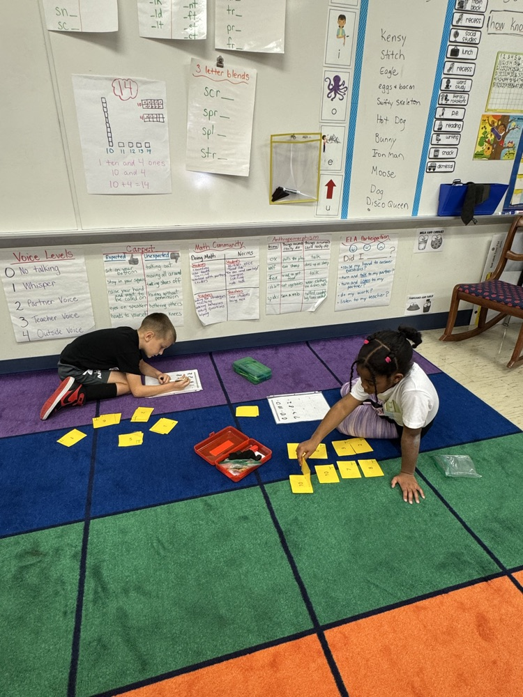 Two first grade students playing a math game  