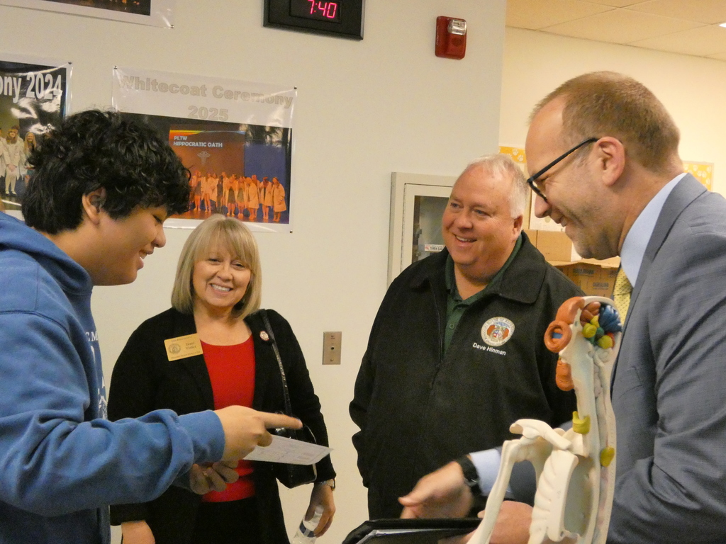 Superintendent helps a student ambassador explain the progression of biomedical coursework to legislators