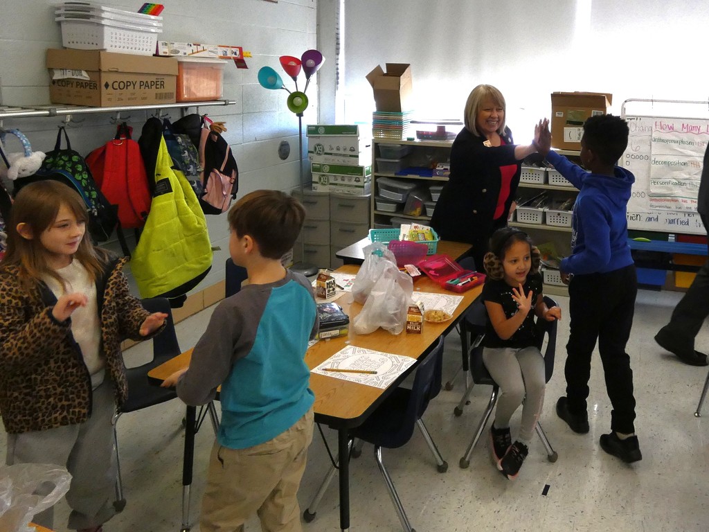 Legislator high-fives a student during morning meeting