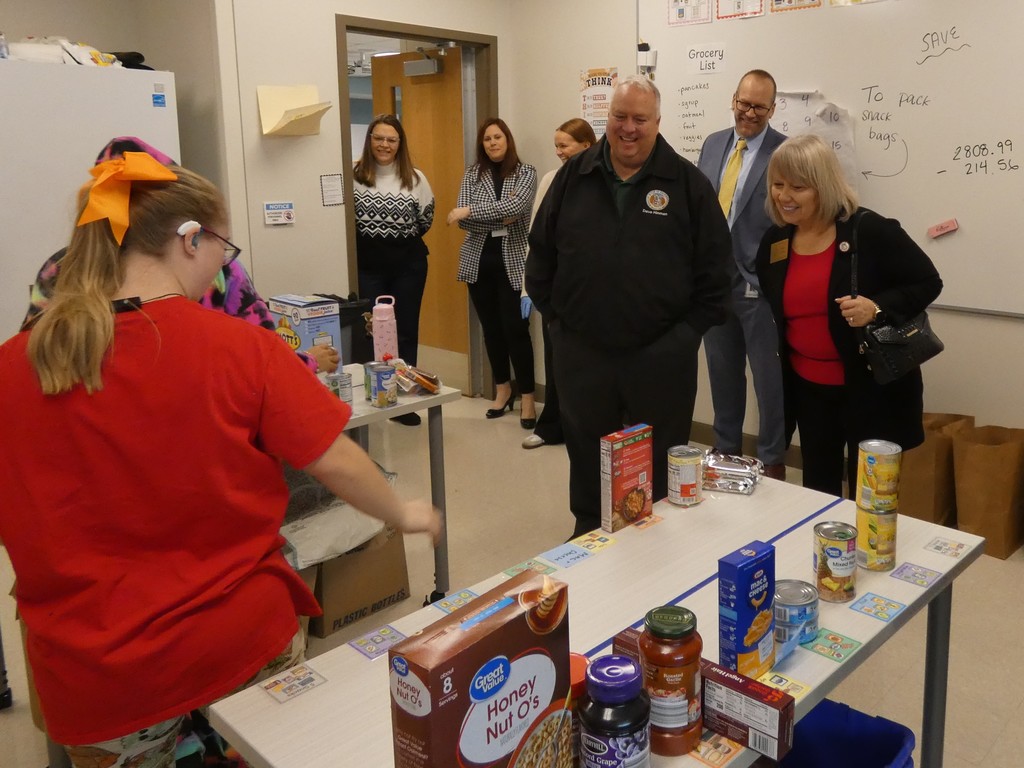 Students share the packing process with reps in the food pantry