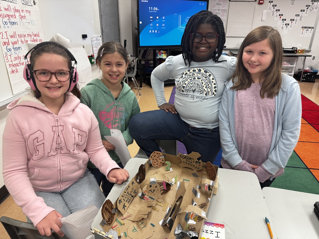 Four third grade girls smiling proudly in front of their cookie inspired pin ball machines.