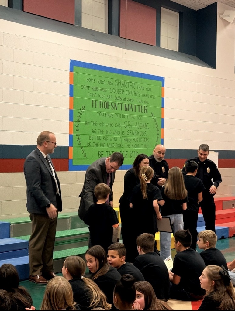 Dr. St. Pierre, Mr. Musgrove, Officer Luu, and Chief of Police Andy Ramirez shaking students' hands as they recieve their graduation certificate.