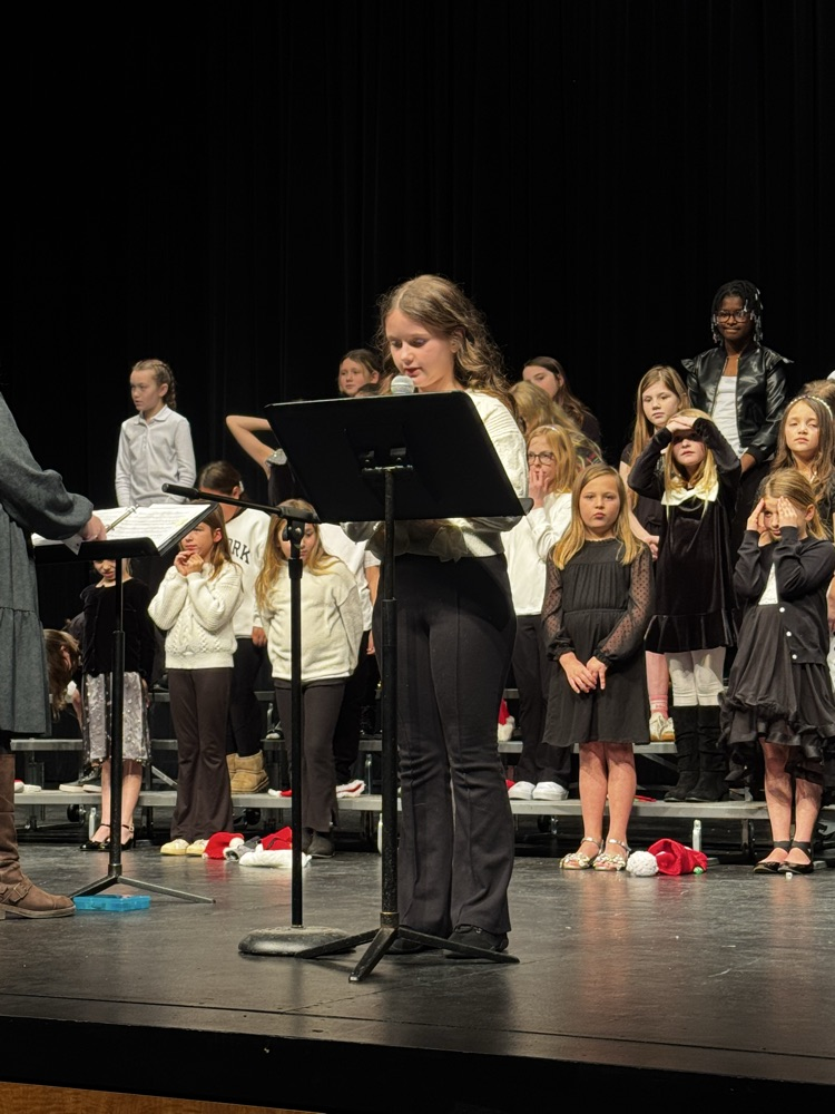 A third grade student leader introducing the next choir song