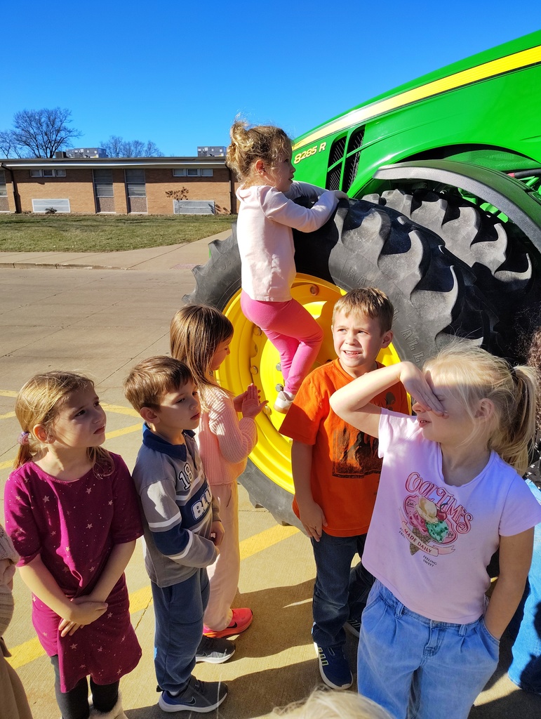 Kindergarteners checking out the size of the tire on the tractor