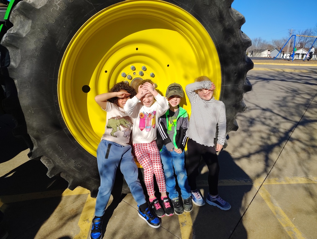 Kindergarteners checking out the size of the tire on the tractor