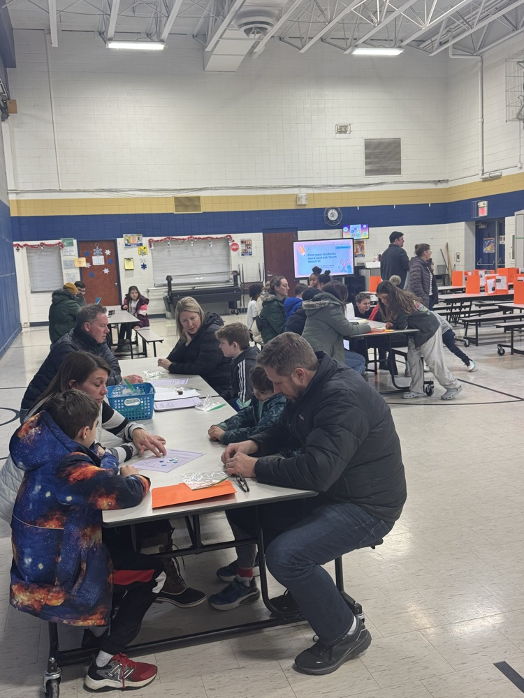 Families sitting at a table playing math games