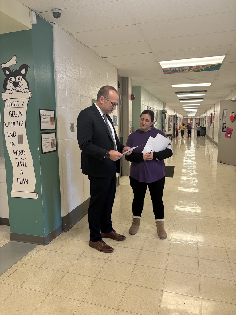 Dr. Henry St. Pierre reading to Mrs. Gerdes'  her Triple E award