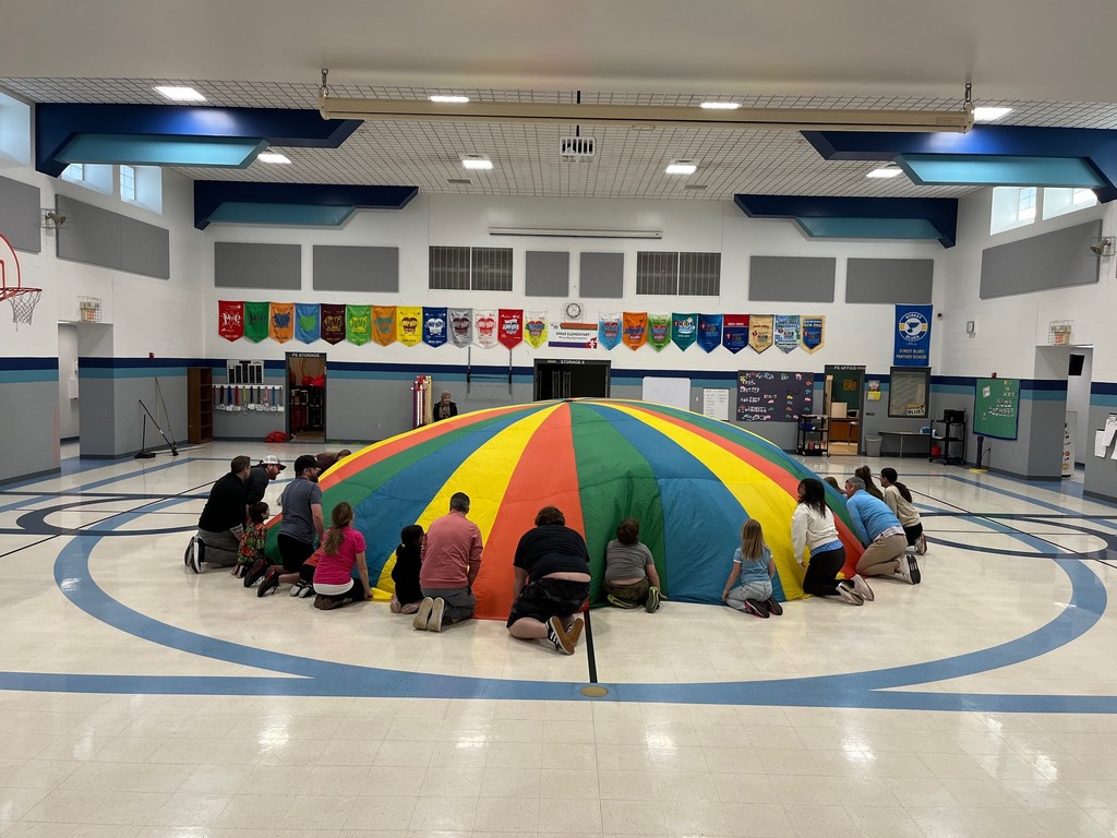 2nd graders and parents parachute in PE