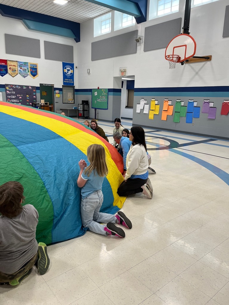 2nd graders and parents parachute in PE
