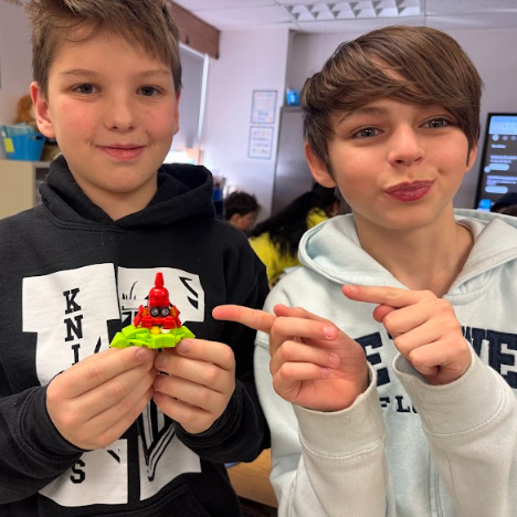 Classmates show off their creature creations, this one made of small legos