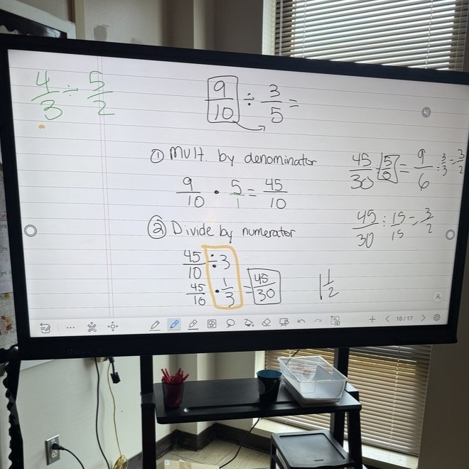 A large screen features student work explaining how they solved a math problem