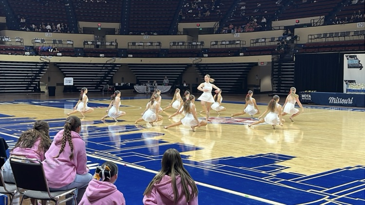 A dance performing a spin while the team is performing around her