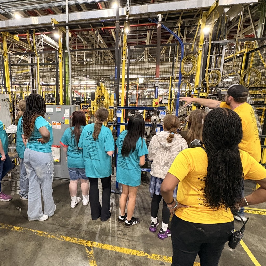 Students stair across factory floor at production equipment
