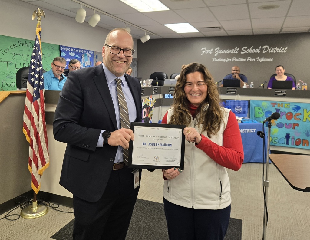 Dr. Henry St. Pierre presenting Dr. Ashlee Vaughn with a certificate at the Board of Education Meeting.