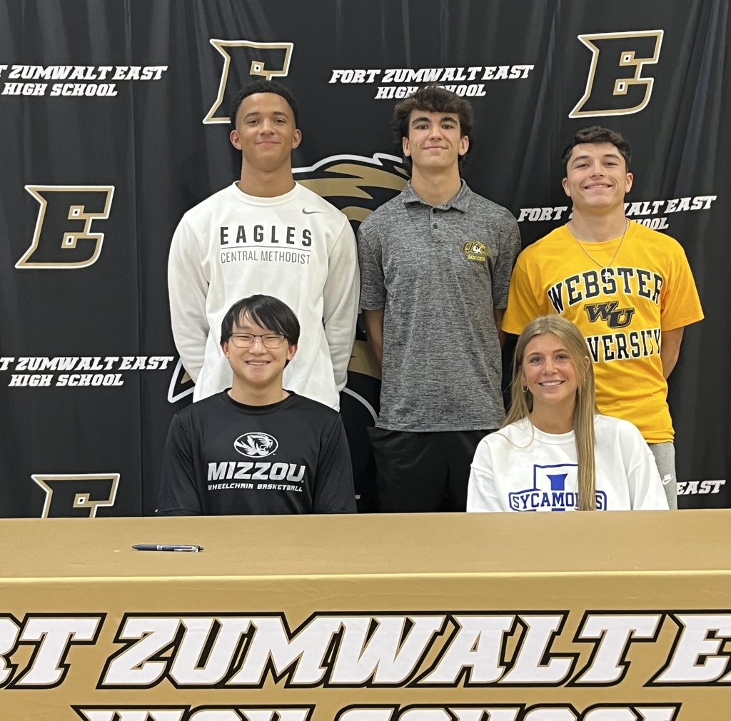 Past Collegiate Athletes Posing for a Signing