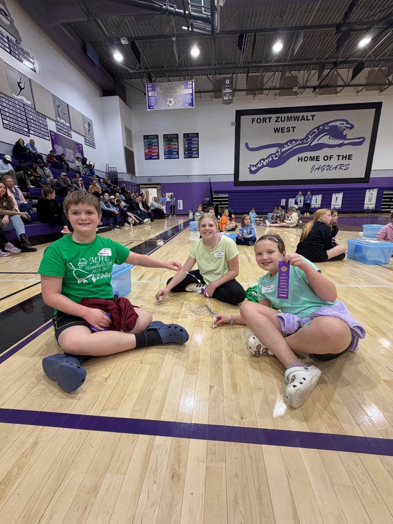 4th-grade students posing with their STEAM Project and participation ribbon