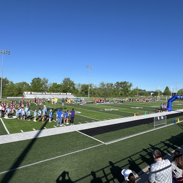 students in teams wait to start their run on the football field
