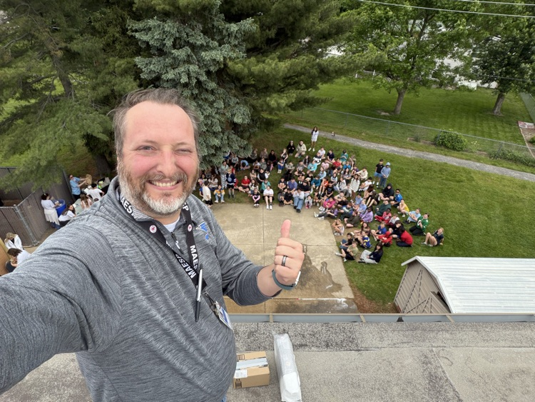 Mr Johnson on a roof giving a thumbs up