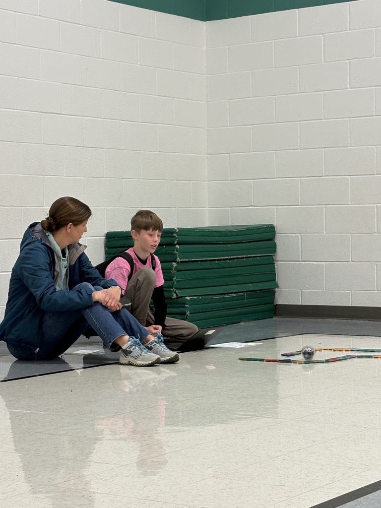 A parent and a son working on their code to get their Sphero robot through the maze