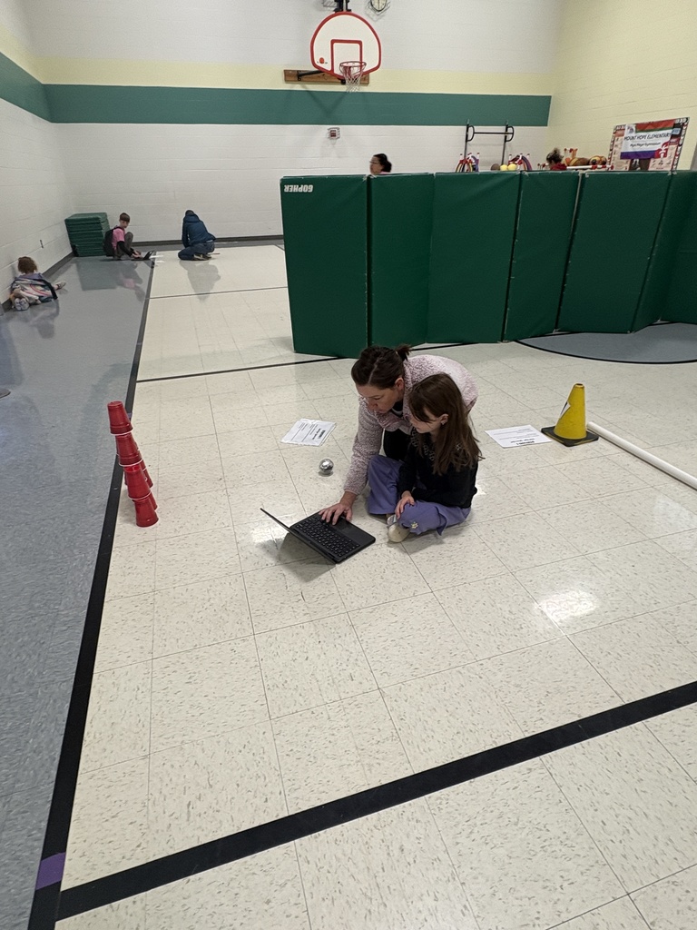 A parent and a daughter working on their code to bowl their Sphero robot 