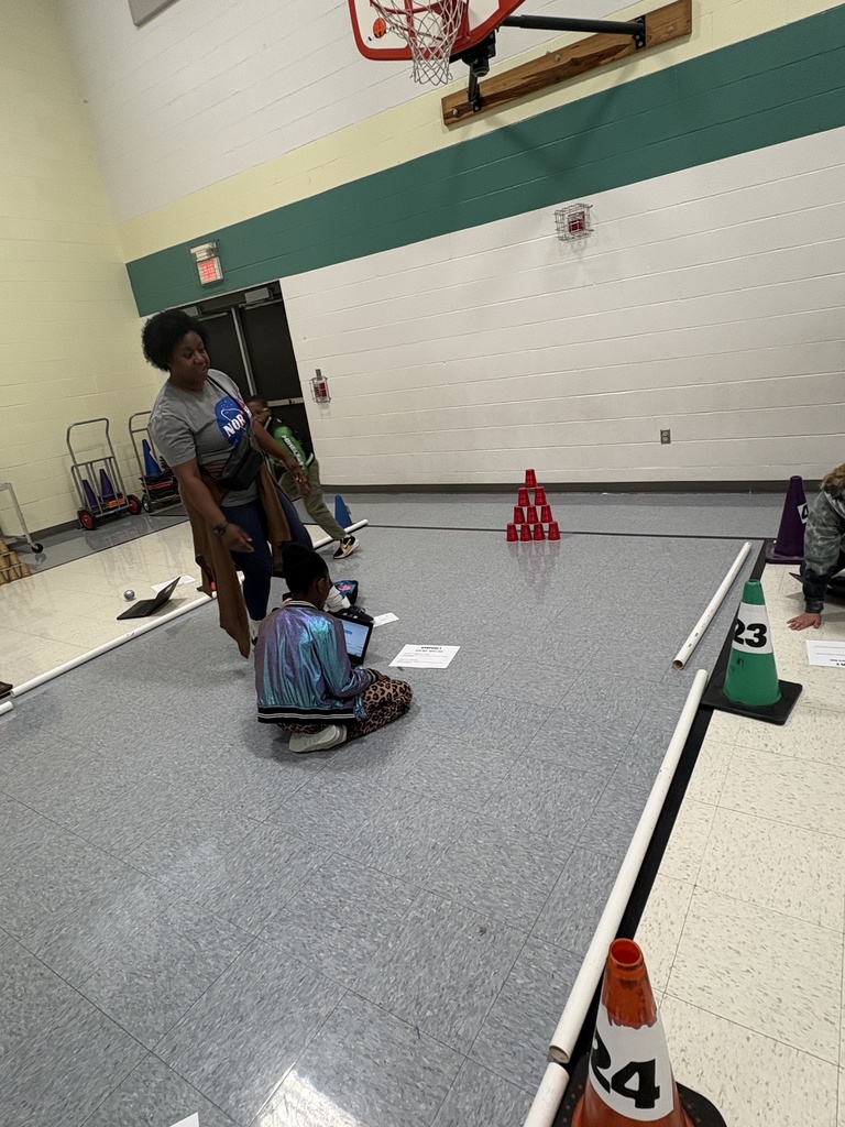 A parent and a daughter working on their code to bowl their Sphero robot 