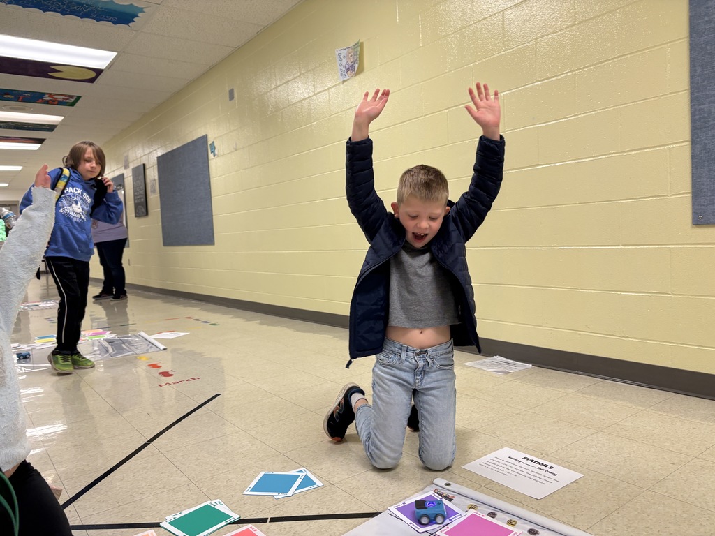 A 1st-grade student celebrating their robot making it to their goal 